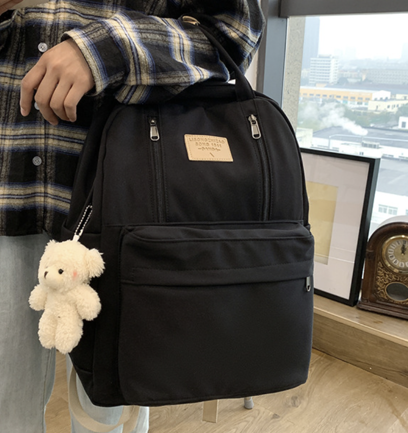 dropshipping large backpack in black with a front pocket and durable fabric, closed with zippers