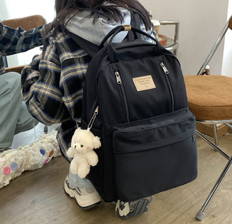 Large front pocket backpack by dropshipping in black with durable fabric and zip closure, 32 by 12 by 42 cm